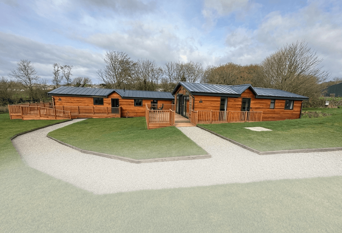Completed timber lodges with decked terraces, landscaped lawns and neat gravel paths